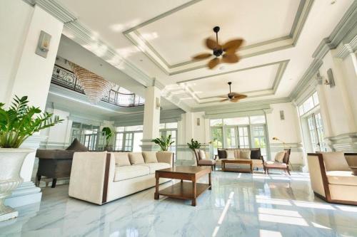 a living room with white furniture and a ceiling at My BanLao Hotel in Luang Prabang