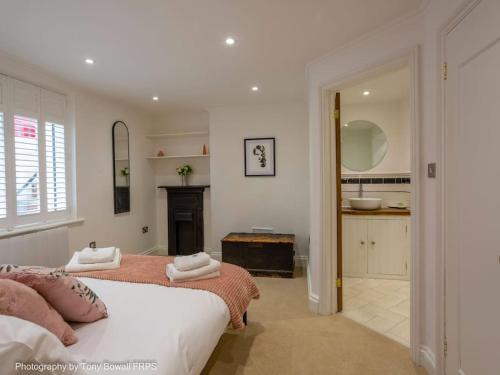 a white bedroom with a bed and a bathroom at Central seaside home with free parking in Brighton & Hove
