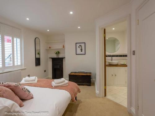 a white bedroom with a bed and a bathroom at Central seaside home with peaceful patio in Brighton & Hove