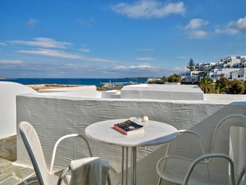 a table and chairs on a balcony with a cake on it at Kanale's Rooms & Suites in Naousa