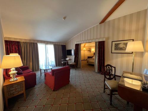 فندق دو لا بيه في لوغانو: غرفة معيشة ذات أثاث احمر في غرفة فندق