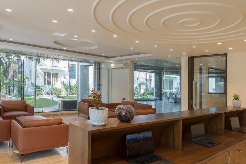a living room with a desk with a laptop on it at The Tanisi Hotels and Resorts, Candolim in Candolim