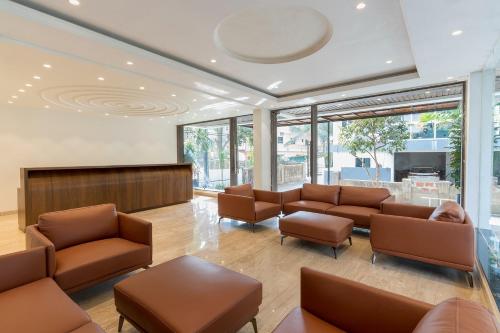 a waiting room with couches and chairs and a television at The Tanisi Hotels and Resorts, Candolim in Candolim