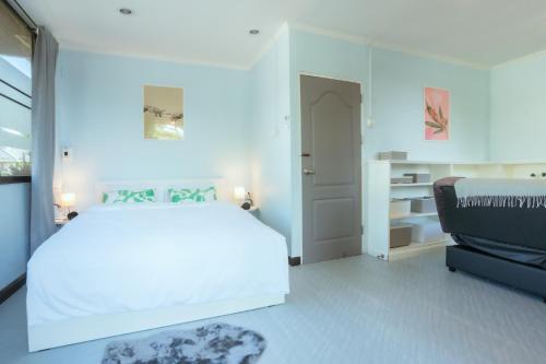 a white bedroom with a bed and a couch at 420 Hostel - Ekkamai Buds & Beds in Bangkok