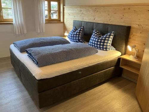 a bedroom with a large bed with blue pillows at Bergbauernhof Wechs in Ofterschwang