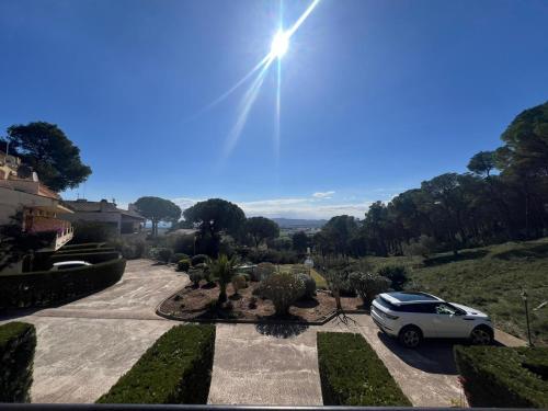 une voiture garée dans une allée avec le soleil dans le ciel dans l'établissement La Dorada 10, à Torroella de Montgrí