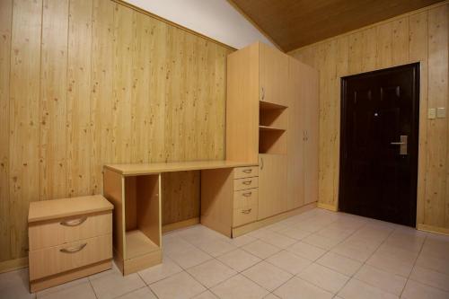 a kitchen with wooden walls and a desk and a door at Forest Crest Nature Hotel and Resort Powered by ASTON in Nasugbu