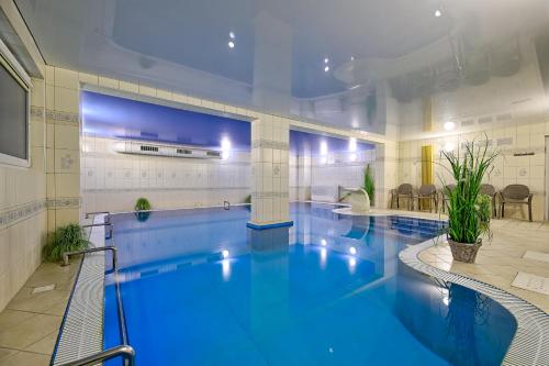 uma grande piscina com água azul num edifício em Hotel Wodnik Twój Hotel z widokiem na morze em Ustronie Morskie