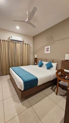 a bedroom with a large bed with blue pillows at Kaloor Residency in Ernakulam