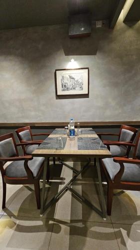 a dining room with a wooden table and chairs at Kaloor Residency in Ernakulam
