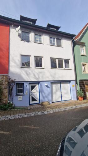 a white building with blue doors and windows at Ferienwohnung Forchtenberg in Forchtenberg
