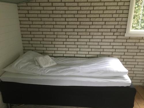a bed in a room with a brick wall at Harvey`s Bed & Breakfast in Hjørring