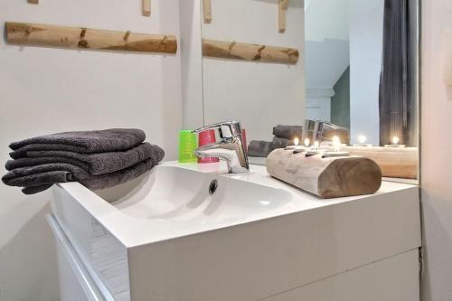 a white bathroom with a sink and a mirror at Chambre d hôtes - studio de 30m2 in Rixensart