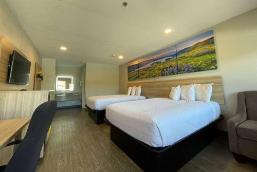 ein Hotelzimmer mit 2 Betten und einem Sofa in der Unterkunft Days Inn by Wyndham Seaworld Lackland AFB in San Antonio
