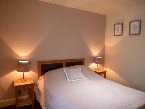 a bedroom with a white bed with two lamps at The Jolly Drover in Liss