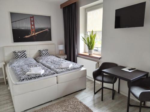 a bedroom with a bed and a table and a desk at Hotel Na Baste in Jablonec nad Nisou