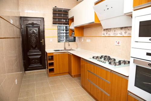 una cucina con lavandino e piano cottura forno superiore di House 13 Apex a Lagos