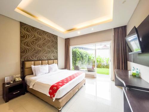 a bedroom with a large bed and a television at New Surya Hotel in Banyuwangi