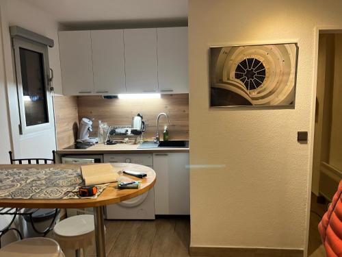 - une petite cuisine avec une table et un comptoir dans l'établissement Studio avec coin nuit vue mer - la ciotat, à La Ciotat