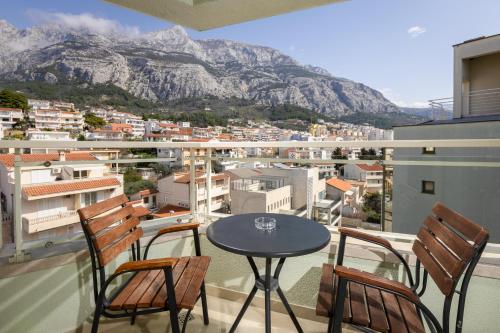 a balcony with a table and chairs and a mountain at Hotel Park Makarska in Makarska