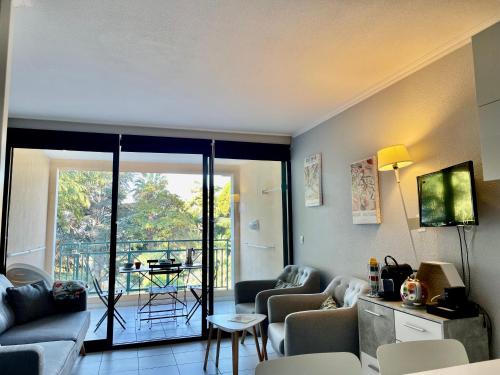 d'un salon avec un canapé et des chaises ainsi que d'un balcon. dans l'établissement CANNES Appartement Duplex Piscine VUE Mer WIFI PARKING CLIM, à Cannes