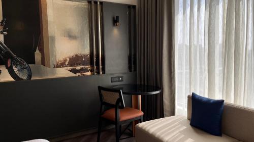 a room with a bed and a table and a chair at Ramada Encore by Wyndham Indore Nipania in Indore