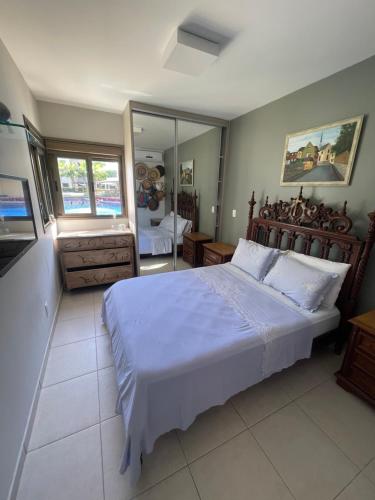 a bedroom with a large bed and a mirror at EKOARA BEIRA MAR 127 in Porto De Galinhas