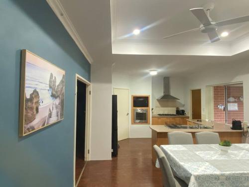 Una sala de estar con una mesa y una cocina. en Falcon Estuary Escape, en Wannanup