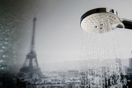 a shower head with the eiffel tower in the background at Campanile Cergy Saint-Christophe in Cergy