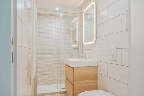 ein weißes Bad mit einem Waschbecken und einem WC in der Unterkunft Petit gîte Sables d' Or 600m plage in Plurien