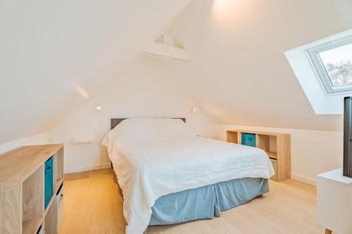 ein weißes Schlafzimmer mit einem Bett und einem Fenster in der Unterkunft Petit gîte Sables d' Or 600m plage in Plurien