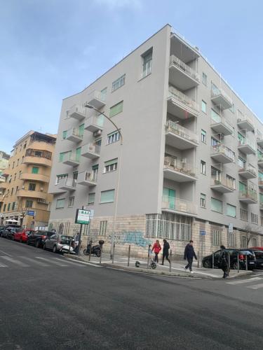 um grande edifício de apartamentos branco numa rua da cidade em Civico 85 em Roma