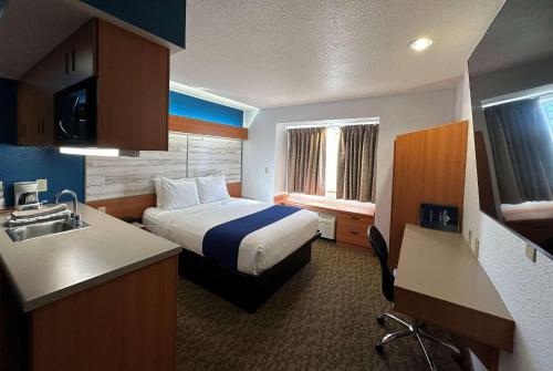 ein Hotelzimmer mit einem Bett und einem Waschbecken in der Unterkunft Microtel Inn & Suites Tomah in Tomah