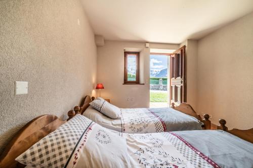 two beds in a room with a window at Le Torrent des Lys in Samoëns