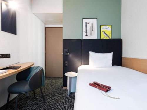 a room with a bed and a desk and a chair at ibis Paris Grands Boulevards Opéra 9e in Paris