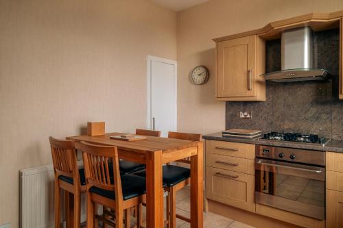 una cucina con tavolo in legno e piano cottura di Fonthill Residence - SJA Stays - 1 Bed Apartment ad Aberdeen