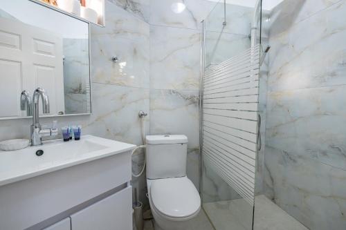 a bathroom with a toilet and a sink and a shower at וילה ריש - וילה מהממת למשפחות עם בריכה מחוממת וג'קוזי in Yarka