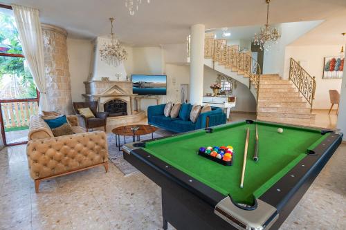 a living room with a pool table in it at וילה ריש - וילה מהממת למשפחות עם בריכה מחוממת וג'קוזי in Yarka