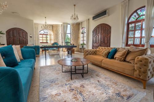 a living room with couches and a ping pong table at וילה ריש - וילה מהממת למשפחות עם בריכה מחוממת וג'קוזי in Yarka