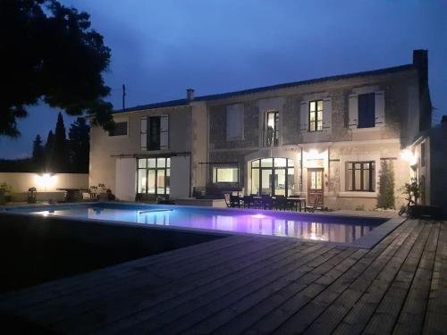 a large house with a swimming pool in front of it at Mas du Cuirassier- Vacances en Provence! in Châteaurenard