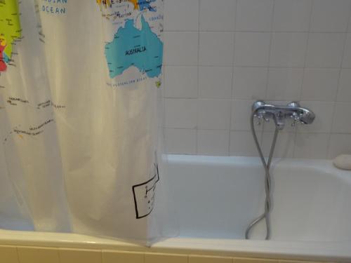 a shower curtain on a bath tub with a faucet at In front of the Beach. in Khónai
