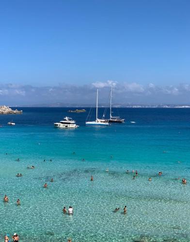 a group of people in the water at a beach at Hotel Corallaro in Santa Teresa Gallura