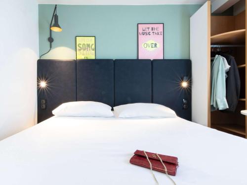 a bedroom with a white bed with a purse on it at ibis Paris Bastille Faubourg St Antoine in Paris