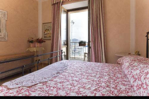 um quarto com uma cama e uma varanda em Piazza Civica em Alghero
