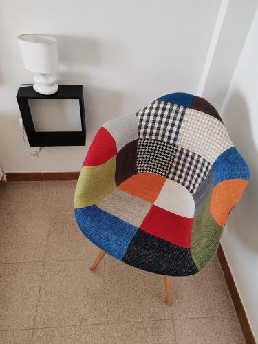 a colorful chair sitting in a room with a tv at Trapani Emotions apartment in Valderice
