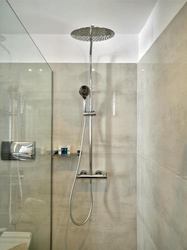 a shower with a glass door in a bathroom at Kanale's Rooms & Suites in Naousa