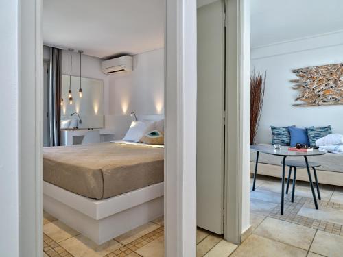 a bedroom with a bed and a table in a room at Kanale's Rooms & Suites in Naousa