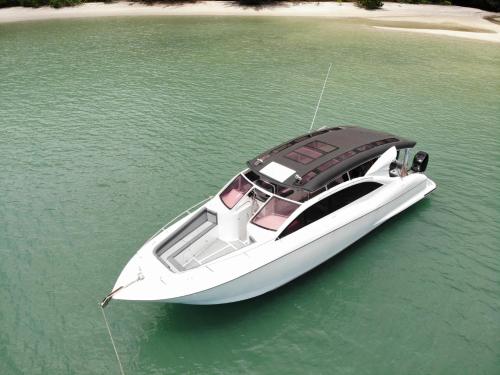 Alunan Resort ALL INCLUSIVE في بيرهينتيان: قارب أبيض في الماء على هيئة ماء