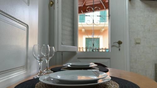科孚城的住宿－Jason's House，一张桌子,上面放着盘子和葡萄酒杯
