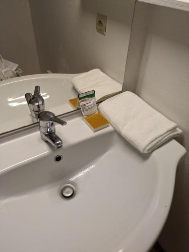 a bathroom sink with a towel and a mirror at Résidence Mes Amours d'Enfants - Les Villas du Lac in Soustons